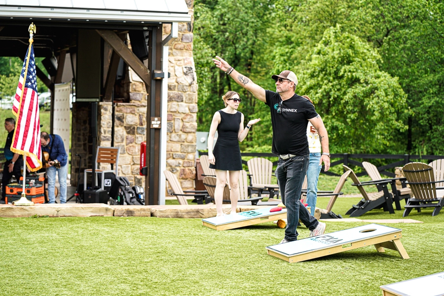 man throwing cornhole bean bag at a corporate event